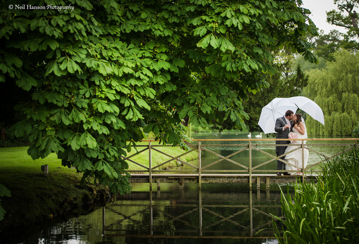 Bride and Groom holding umbrellas on their Ardington House Wedding Day